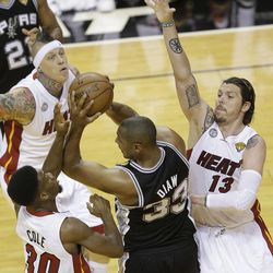 San Antonio Spurs center Boris Diaw (33) looks to pass against Miami Heat point guard Norris Cole (30) and Miami Heat shooting guard Mike Miller (13) during the first half of Game 2 of the NBA Finals basketball game, Sunday, June 9, 2013 in Miami. 