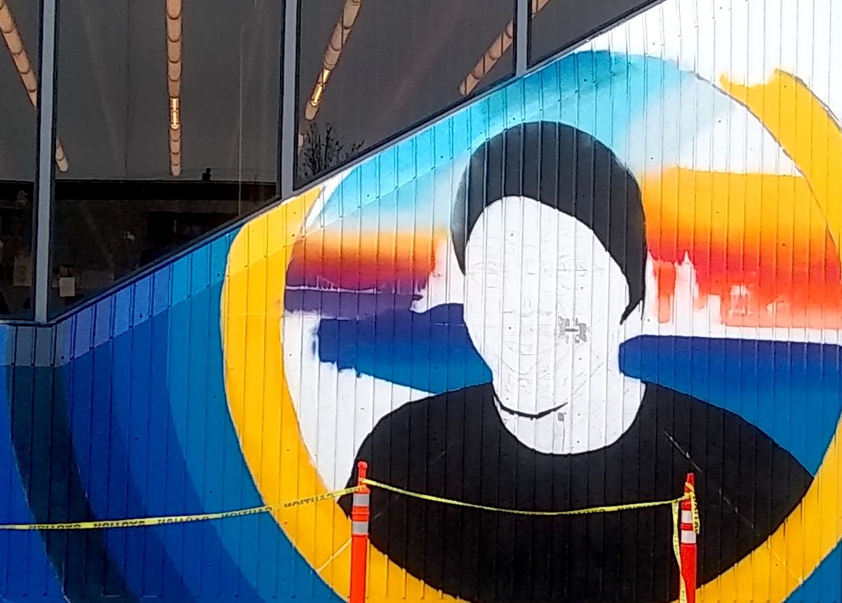 A mural on the side of Fruitvale Station depicting a smiling Oscar Grant, half-finished.