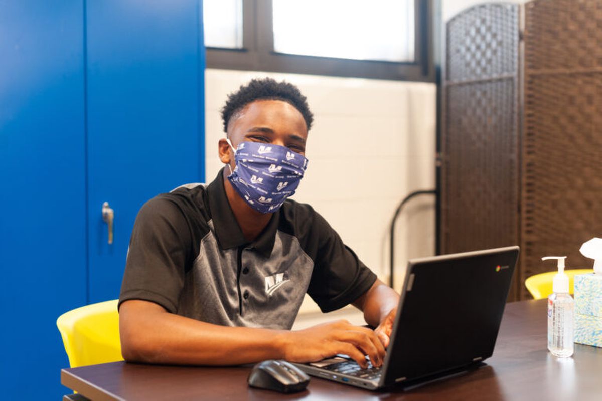 Masked student sitting at desk