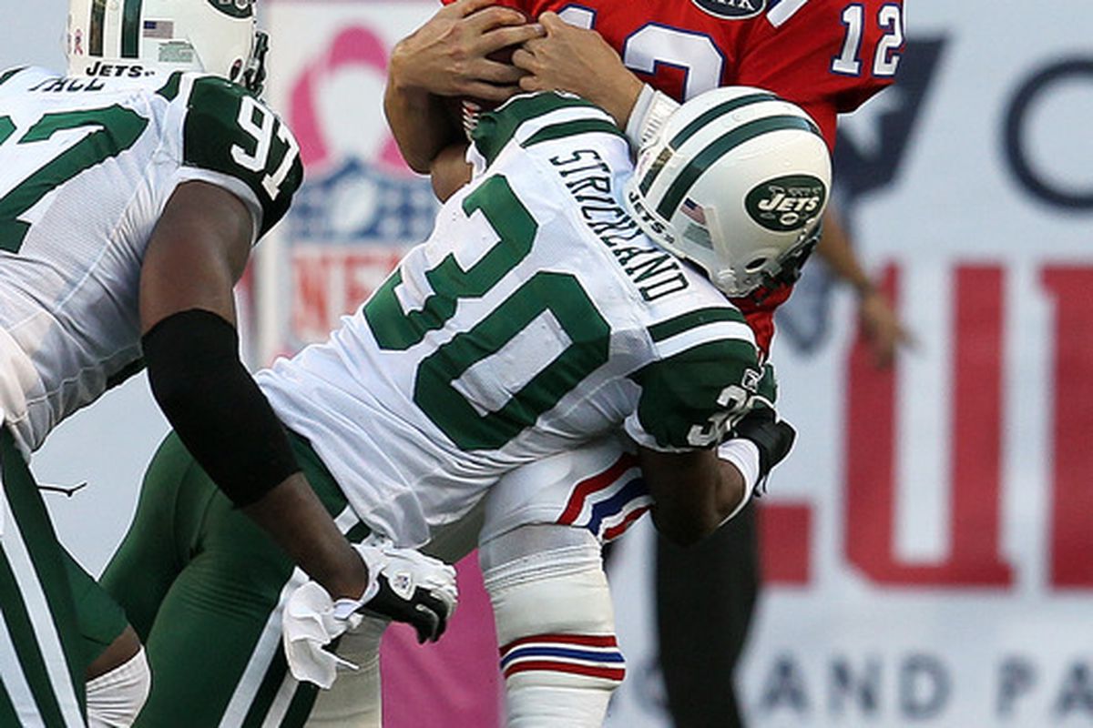 FOXBORO, MA - OCTOBER 9:   Donald Strickland #30 of the New York Jets sacks Tom Brady #12 of the New England Patriots in the second half at Gillette Stadium on October 9, 2011 in Foxboro, Massachusetts. (Photo by Jim Rogash/Getty Images)
