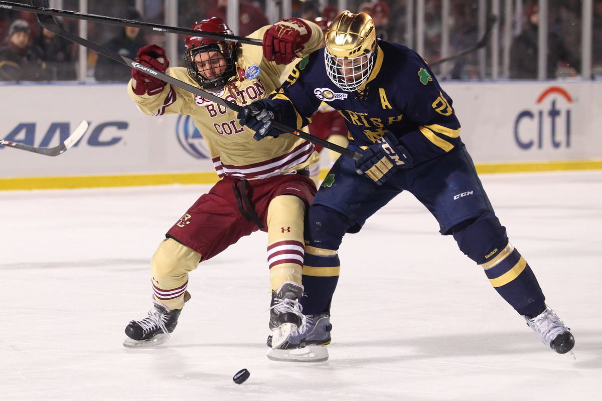 Boston, MA - Boston College senior forward Bill Arnold (24) tangles with Notre Dame senior defenseman Stephen Johns (28) during a breakaway in the first period of the Frozen Fenway matchup at Fenway Park on Saturday, January 4, 2014. Photo by Matth