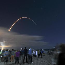 In this photo taken with a long exposure, hundreds line the beach north of the Cocoa Beach Pier in Florida to watch launch of the Orbital ATK"™s Cygnus spacecraft off the United Launch Alliance Atlas V rocket at Cape Canaveral Air Force Station, Tuesday, March 22, 2016. Fresh supplies shipped out late Tuesday for the International Space Station, where the shelves finally are getting full after a string of failed deliveries.
