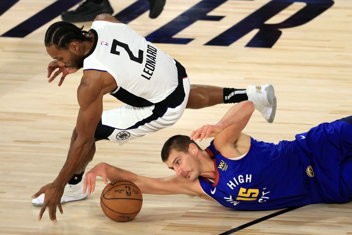 Kawhi Leonard of the LA Clippers and Nikola Jokic of the Denver Nuggets scramble for a loose ball during the first quarter in Game Five of the Western Conference Second Round during the 2020 NBA Playoffs at The Field House at the ESPN Wide World Of Sports Complex on September 11, 2020 in Lake Buena Vista, Florida