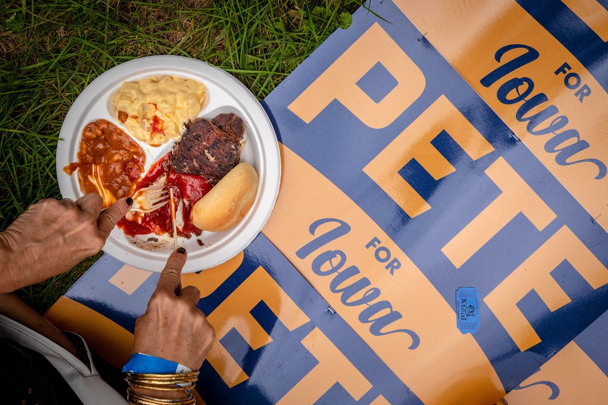 Steak is eaten atop a Pete Buttigieg campaign poster