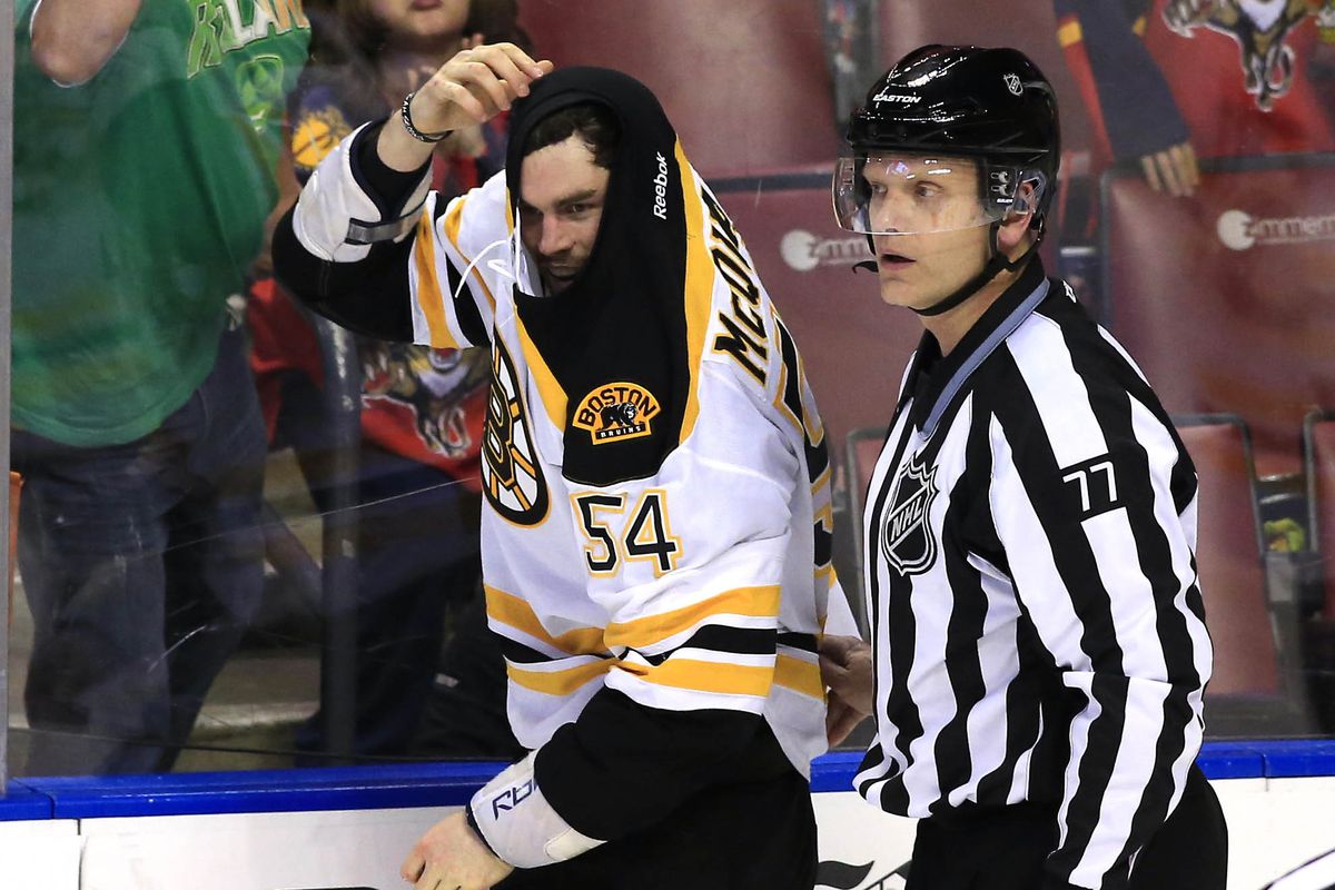 Adam McQuaid mugs for the camera as he is escorted to the box