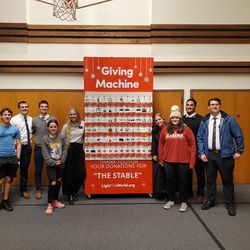 Teens and Latter-day Saint missionaries stand next to the homemade giving machine built for the Seguin Stable Project. The machine, designed to be like the Giving Machines, is helping furnish apartments for Afghan refugees in San Antonio, Texas.