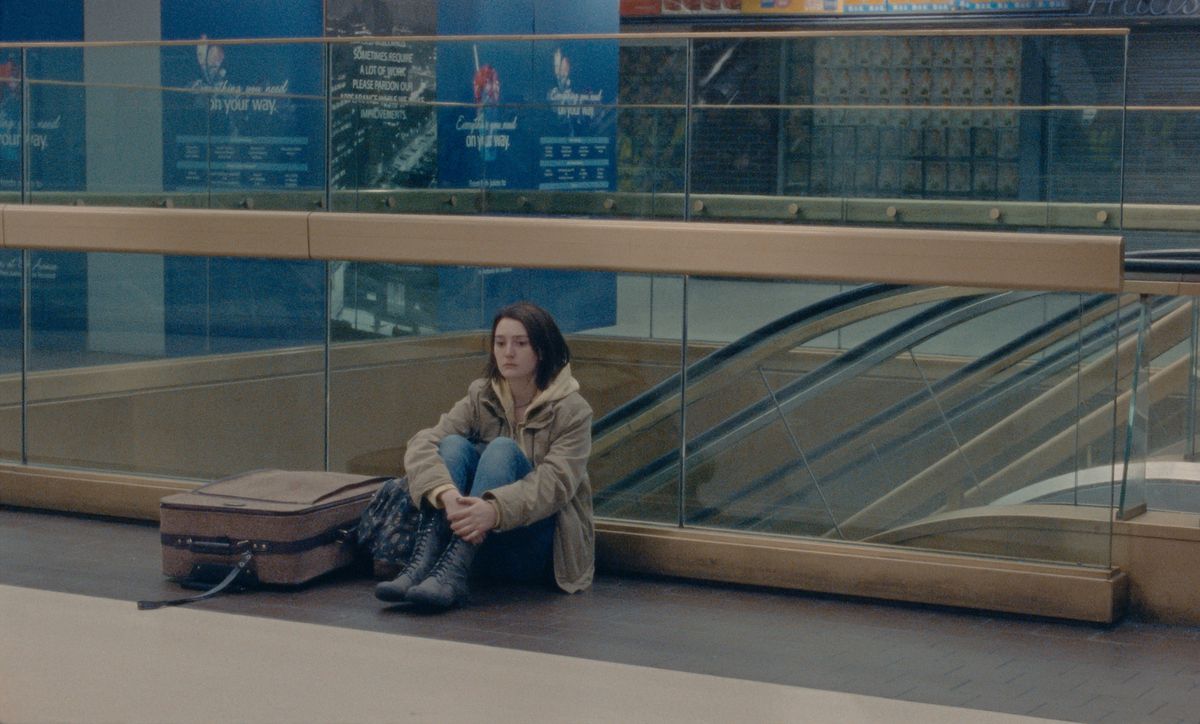 a young woman sits on the floor of penn station
