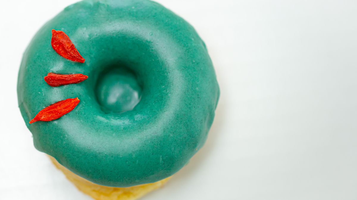 A blue green frosted doughnut