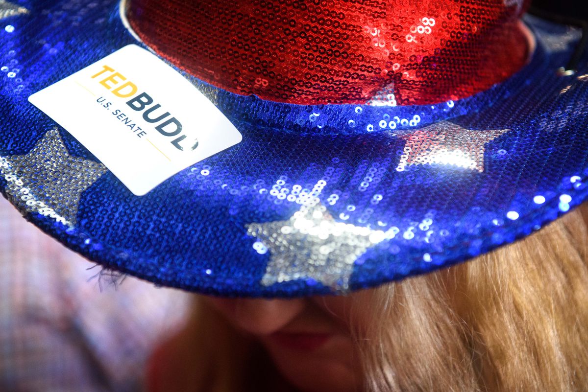 A sparkly sequin hat in the pattern of an American flag, with a “TED BUDD” sticker on the brim.
