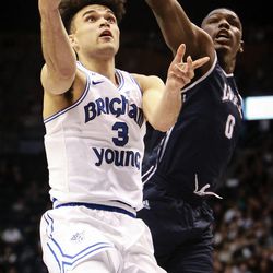 Brigham Young Cougars guard Elijah Bryant (3) lays the ball in under the outstretched arm of Loyola Marymount Lions forward Eli Scott (0) as the Brigham Young Cougars take on the Loyola Marymount Lions at the Marriott Center in Provo on Thursday, Jan. 18, 2018.
