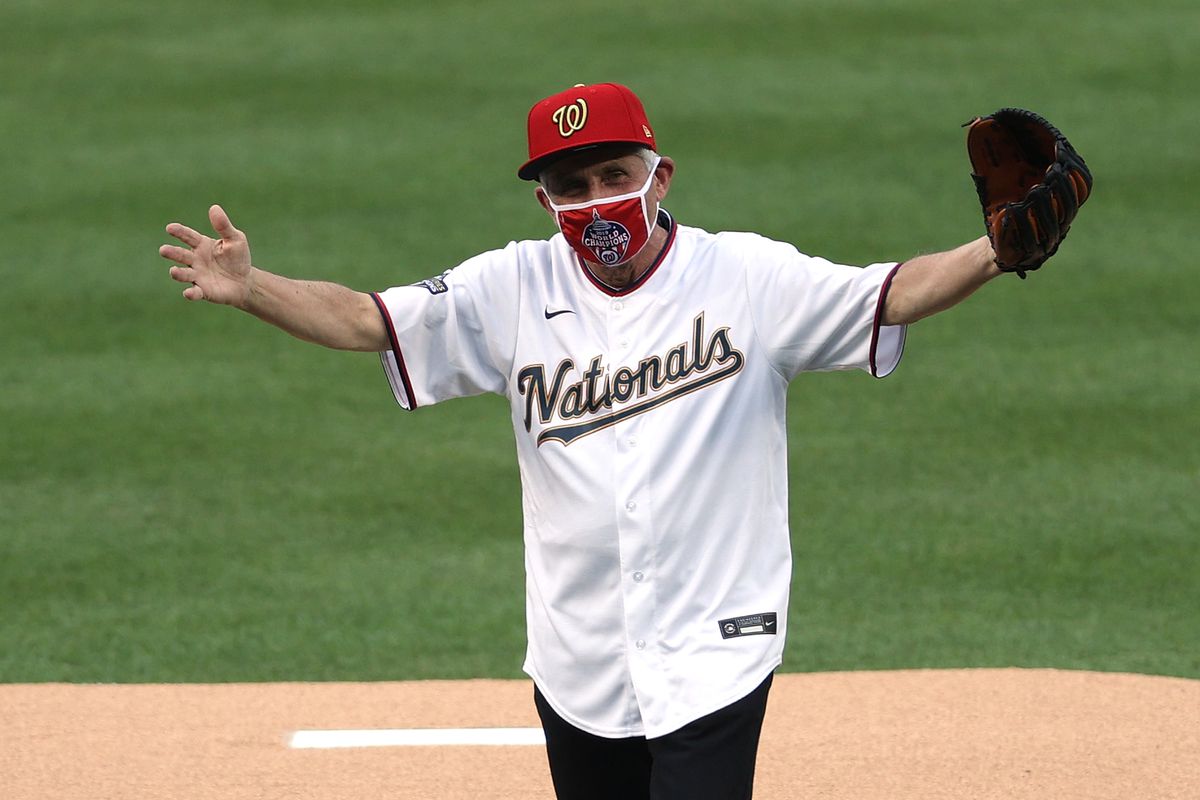 Dr. Anthony Fauci wears a Washington Nationals hat, face mask, and jersey while celebrating his ceremonial first pitch at the Nationals’ opener against the Yankees in July