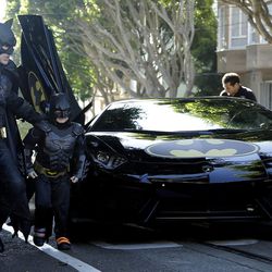 Miles Scott, dressed as Batkid, second from left, exits the Batmobile with Batman to save a damsel in distress in San Francisco, Friday, Nov. 15, 2013. San Francisco turned into Gotham City on Friday, as city officials helped fulfill Scott's wish to be "Batkid." Scott, a leukemia patient from Tulelake in far Northern California, was called into service on Friday morning by San Francisco Police Chief Greg Suhr to help fight crime, The Greater Bay Area Make-A-Wish Foundation says.