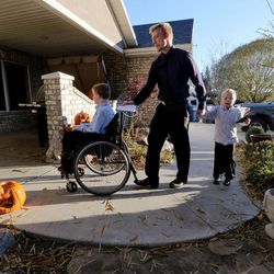 Nathan Honey helps two of his little brothers  Joshua and Anthony Sunday, Nov. 16, 2014, into their home after church. Nathan is an American Fork High football player and helps out with his brothers who struggle with muscular dystrophy. 