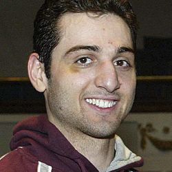 In this Feb. 17, 2010, photo, Tamerlan Tsarnaev, left, smiles after accepting the trophy for winning the 2010 New England Golden Gloves Championship from Dr. Joseph Downes, right, in Lowell, Mass. Tsarnaev, 26, who had been known to the FBI as Suspect No. 1 in the Boston Marathon Explosions and was seen in surveillance footage in a black baseball cap, was killed overnight on Friday, April 19, 2013, officials said. 