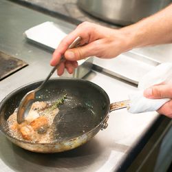 Butter, garlic, and thyme are added to the pan and chef Glocker bastes the sweetbreads.