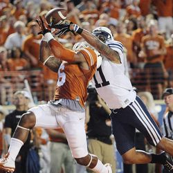 Texas' Quandre Diggs makes an interception in the end zone behind BYU's Terenn Houk as BYU and Texas play Saturday, Sept. 6, 2014, in Austin, Texas.