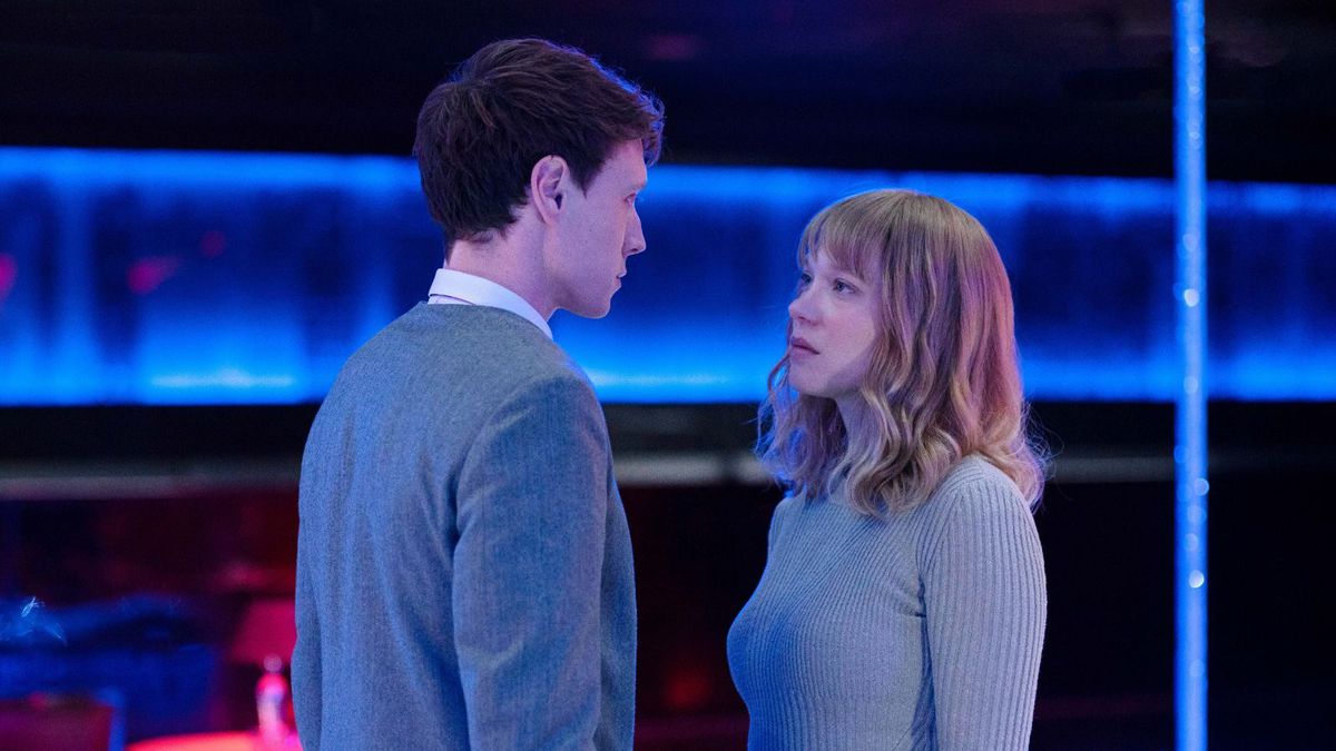 Gabrielle (Léa Seydoux) and Louis (George MacKay), a pale man and woman in pale blue-grey sweaters, stand opposite each other and look into each others’ eyes in an abstract neon-blue space in a scene from The Beast