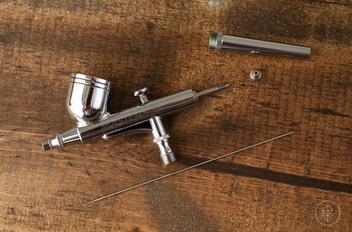 A disassembled airbrush showing the major components.