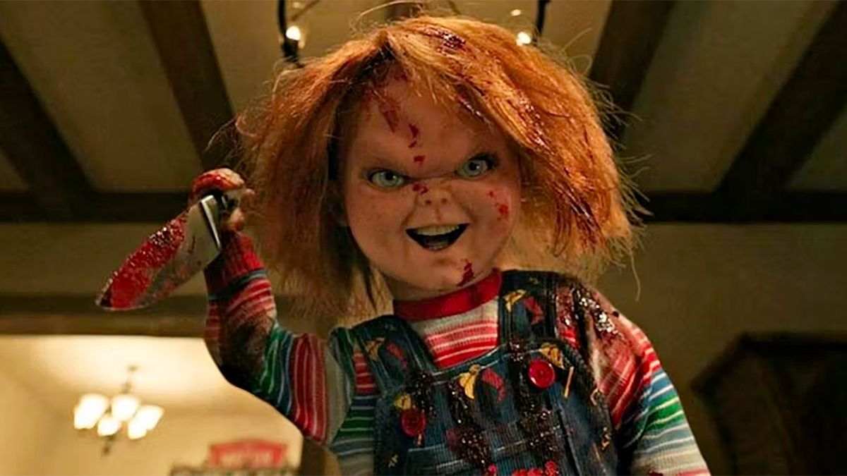 Chucky holds a bloody knife aloft ready to stab someone in a still from season 3 of Chucky