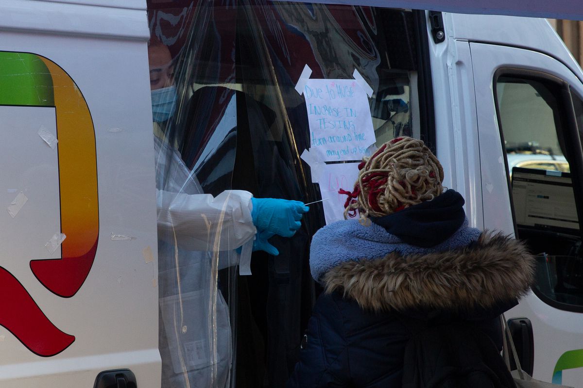 Health care workers test people for COVID at a mobile lab outside Brooklyn Borough Hall, Dec. 20, 2021.