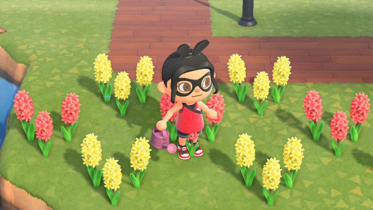 An Animal Crossing character stands around yellow and red hyacinths.