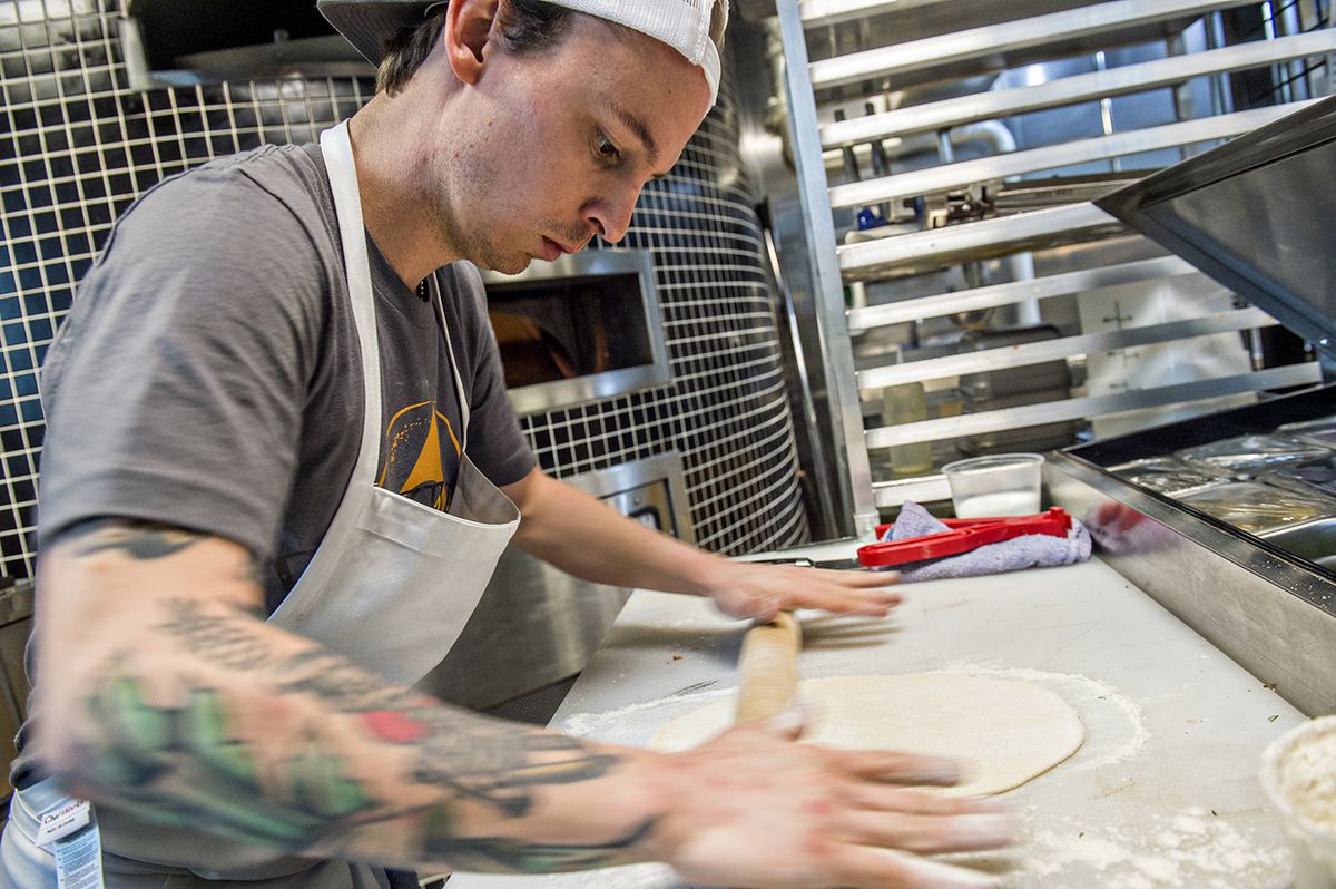 Rolling out super thin dough for Roman style pizza at Pizzeria Coperta.
