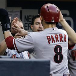 Arizona Diamondbacks' Gerardo Parra is congratulated returning to the dugout after scoring in a sacrifice fly against the San Diego Padres during the first inning of a baseball game in San Diego, Friday, June 14, 2013.  Parra had doubled to start the inning. 