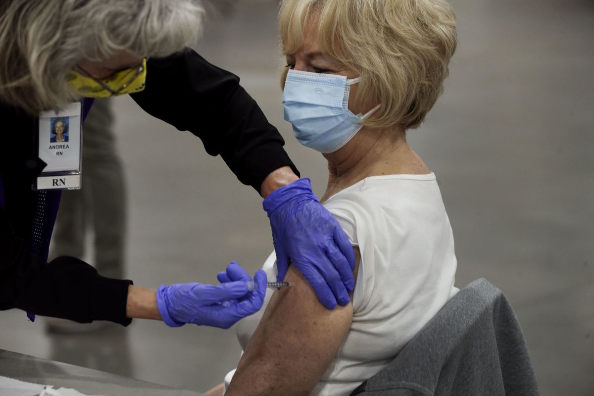 Florence Conover, of Sandy, right, receives a COVID-19 vaccination at the Mountain America Exposition Center in Sandy on Thursday, Feb. 11, 2021.