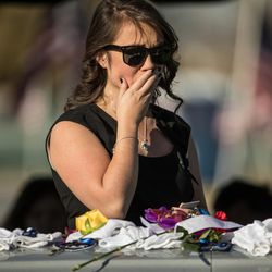 Jessica Le, fiancee of fallen West Valley police officer Cody Brotherson, stands in front of Brotherson's casket at the conclusion of a graveside service at Valley View Memorial Park in West Valley City on Monday, Nov. 14, 2016.