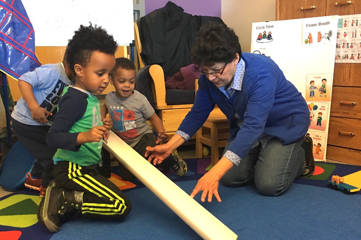 Sheryl Robledo, an early childhood coach, plays with preschool students at a Sewall Child Development Center site in far northeast Denver.