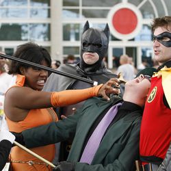 Comic Con attendees dressed as a Batman characters pose for a photo as they wait in line during the preview night for the annual Comic Con International 2009 pop-culture convention held in San Diego Wednesday, July 22, 2009. (AP Photo/Denis Poroy)