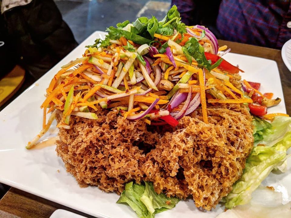 A cloud of crispy fried catfish topped with a salad of thinly sliced green apple, carrot, and red onion