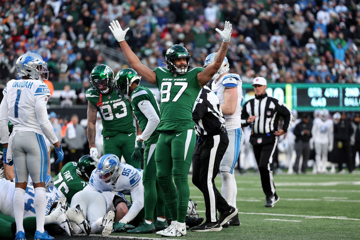 C.J. Uzomah #87 of the New York Jets celebrates a touchdown by Zach Wilson #2 during the fourth quarter against the Detroit Lions at MetLife Stadium on December 18, 2022 in East Rutherford, New Jersey.