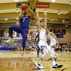 BYU guard Alex Barcello (4) tries to guard Kansas guard Devon Dotson (1) as he goes up for a shot during the first half of an NCAA college basketball game Tuesday, Nov. 26, 2019, in Lahaina, Hawaii. 