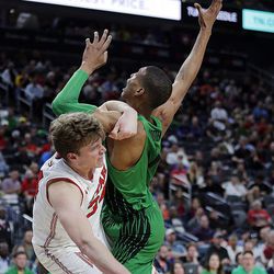 Utah Utes forward Jayce Johnson gets tangled up with Oregon Ducks forward Kenny Wooten after Johnson attempts a shot during the Pac-12 basketball tournament in Las Vegas on Thursday, March 8, 2018.