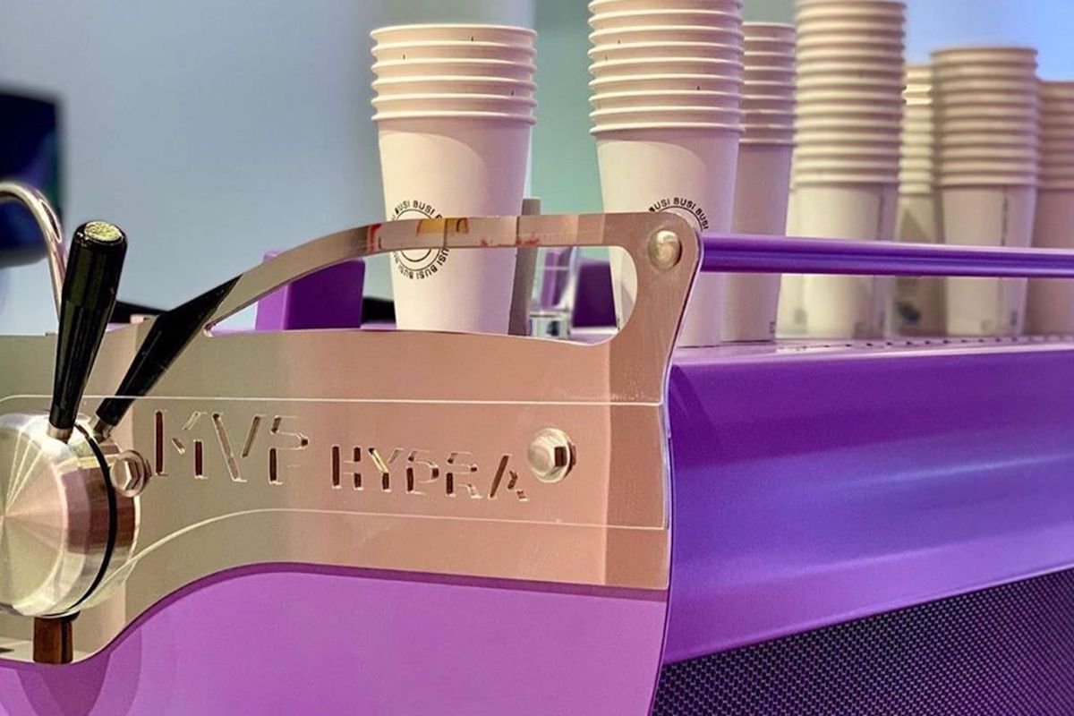 The purple coffee machine at Busi Coffee, with cups stacked on top