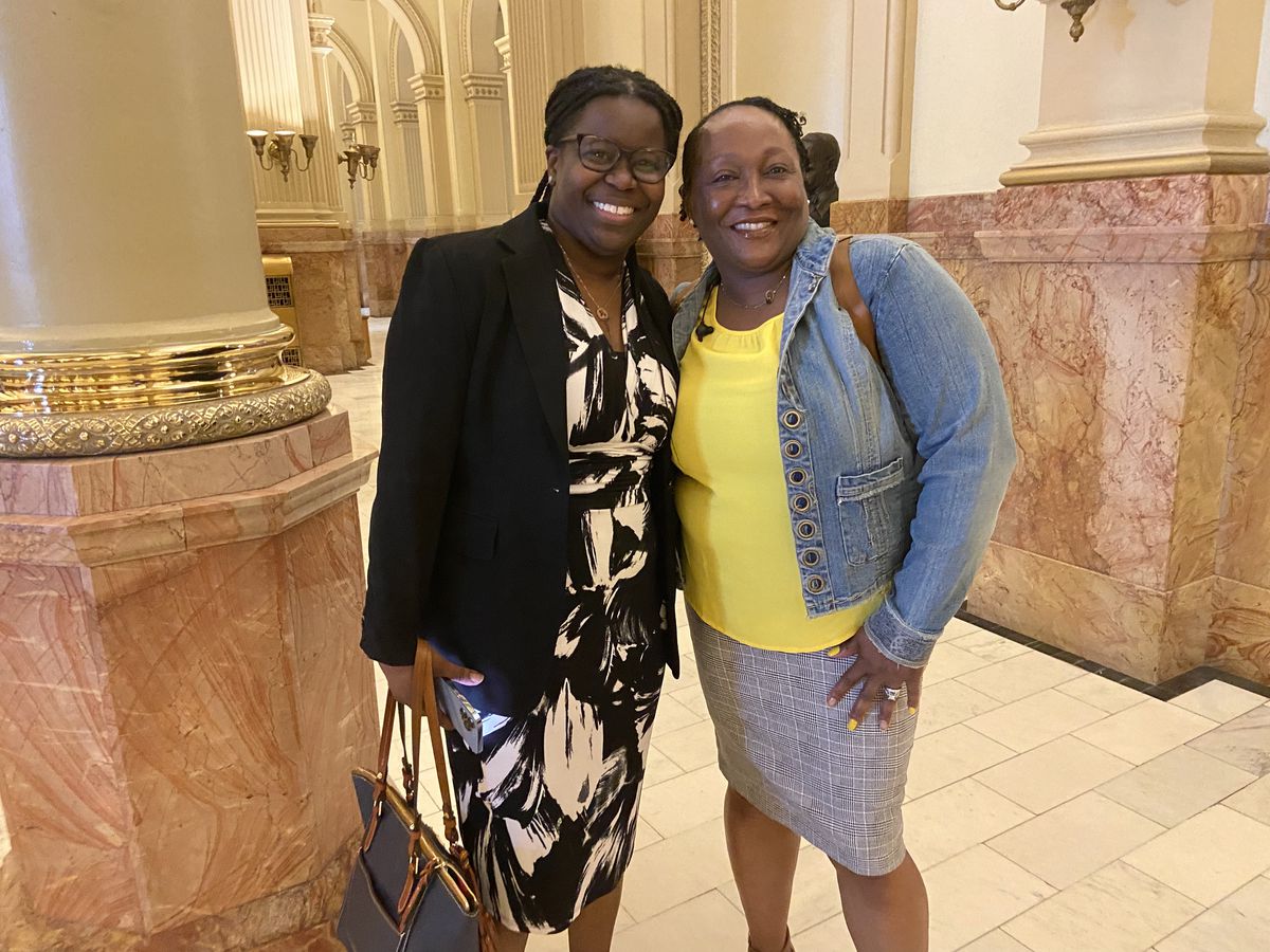 Two smiling women in dresses and jackets smile for a posed photo. They are Nekedra Danyelle Bullock, lead coach with Finish What You Start at Pikes Peak Community College, and student Day Grayson, who is changing her career to go into medical billing and coding.
