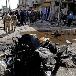 Iraqi security forces inspect the site of a car bomb attack in Basra, 340 miles (550 kilometers) southeast of Baghdad, Iraq, Sunday, June 16, 2013. Most of the car bombs hit Shiite-majority areas and were the cause of most of the casualties, killing tens. The blasts hit half a dozen cities and towns in the south and center of the country. 