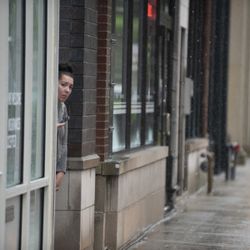 Priscilla Badell peers around the corner while staying out from the rain. | Colin Boyle/Sun-Times