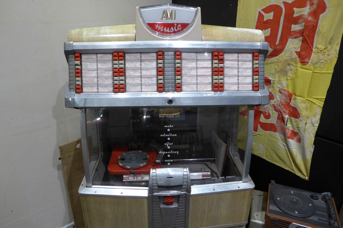 An old Rock-Ola jukebox with neon at the top and visible turntable.