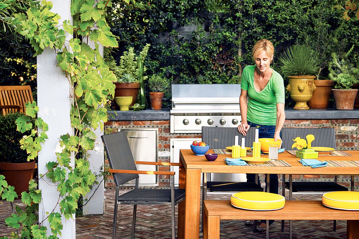 Woman setting table in outdoor kitchen