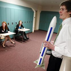Peter Hartvigsen holds a rocket he presented to judges in the Science category, while Stephanie Hedges and Haley Holland wait outside the Social Science room during the Sterling Scholar preliminary judging at Northridge High School in Layton on Wednesday.