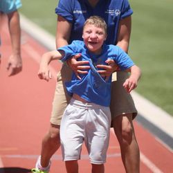 Emily Raleigh helps Tucker Doak, 12, compete in the assisted walk event at the Special Olympics Utah 2013 Harmons Summer Games at Herriman High School in Herriman on Thursday, June 13, 2013.