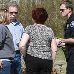 An American Fork police officer talks with residents during an investigation of a shooting Friday, April 5, 2013, at 582 N. 500 East.