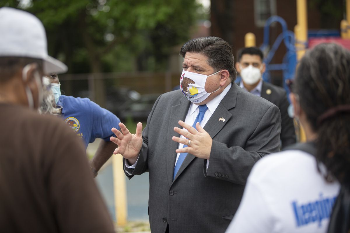 Gov. J.B. Pritzker talks to residents at a mobile COVID-19 testing station at Edward Coles School in Chicago July 8.