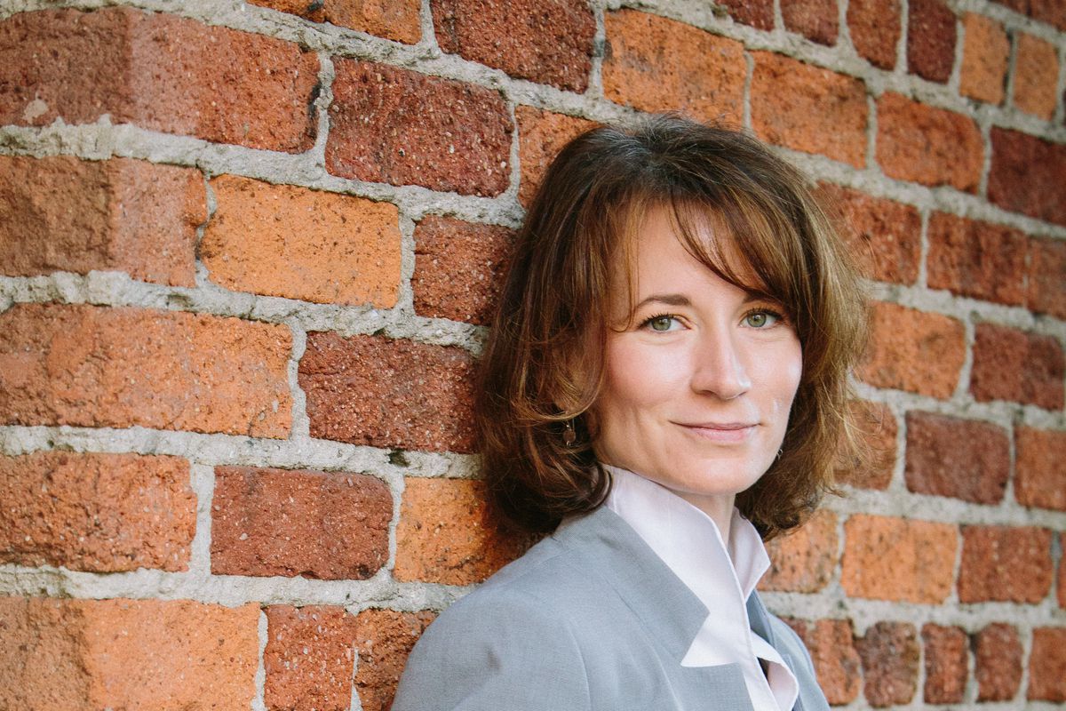 Pam Kostka, the new CEO of All Raise, standing in front of a brick wall.
