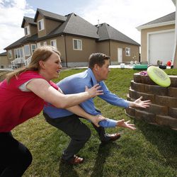 Scott and Sunny Johnson compete for a frisbee while plaing with their kids at their home in Orem on Tuesday, March 29, 2016.