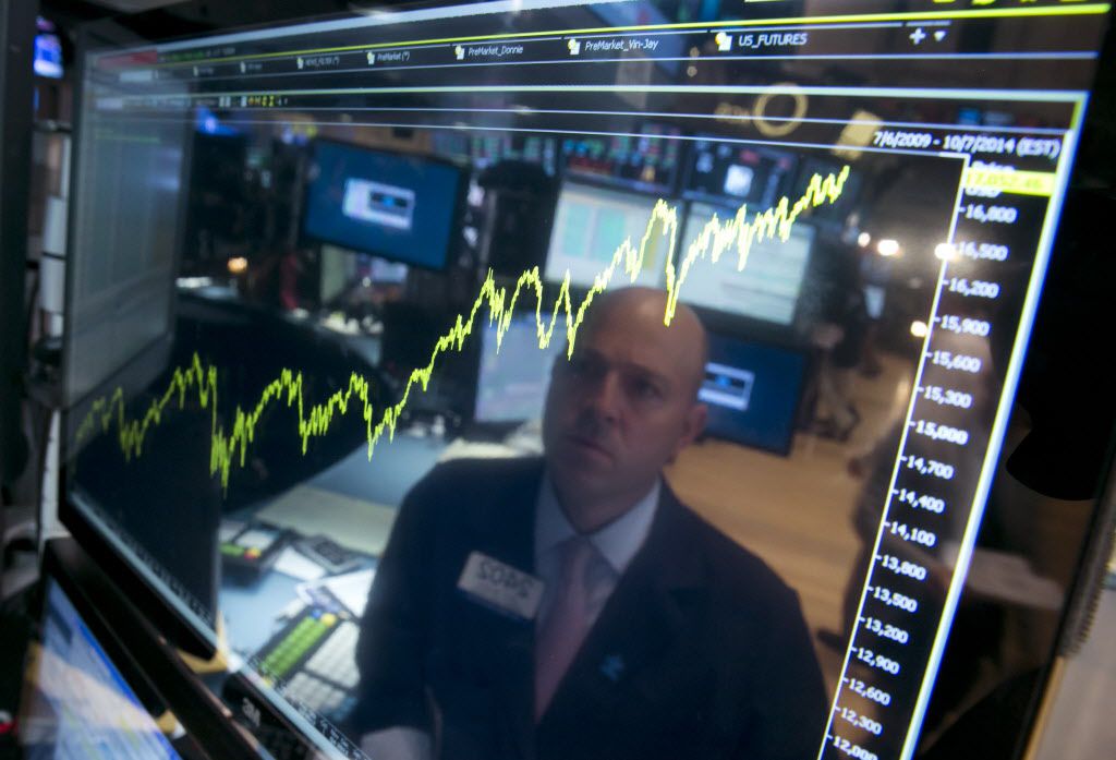 <small><strong>Specialist Jay Woods is reflected in a screen at his post that shows five years of the Dow Jones industrial average, on the floor of the New York Stock Exchange. | AP file</strong></small>