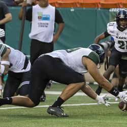 Hawaii defensive lineman Manly Williams, front, recovers a BYU fumble in the end zone for a touchback in the second half of the Hawaii Bowl NCAA college football game, Tuesday, Dec. 24, 2019, in Honolulu. Hawaii defensive back Michael Washington is at right rear.