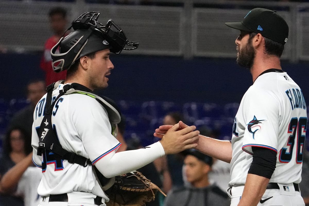Miami Marlins catcher Nick Fortes (54) celebrates with relief pitcher Dylan Floro (36) after defeating the Texas Rangers in game two of a double header at loanDepot park.